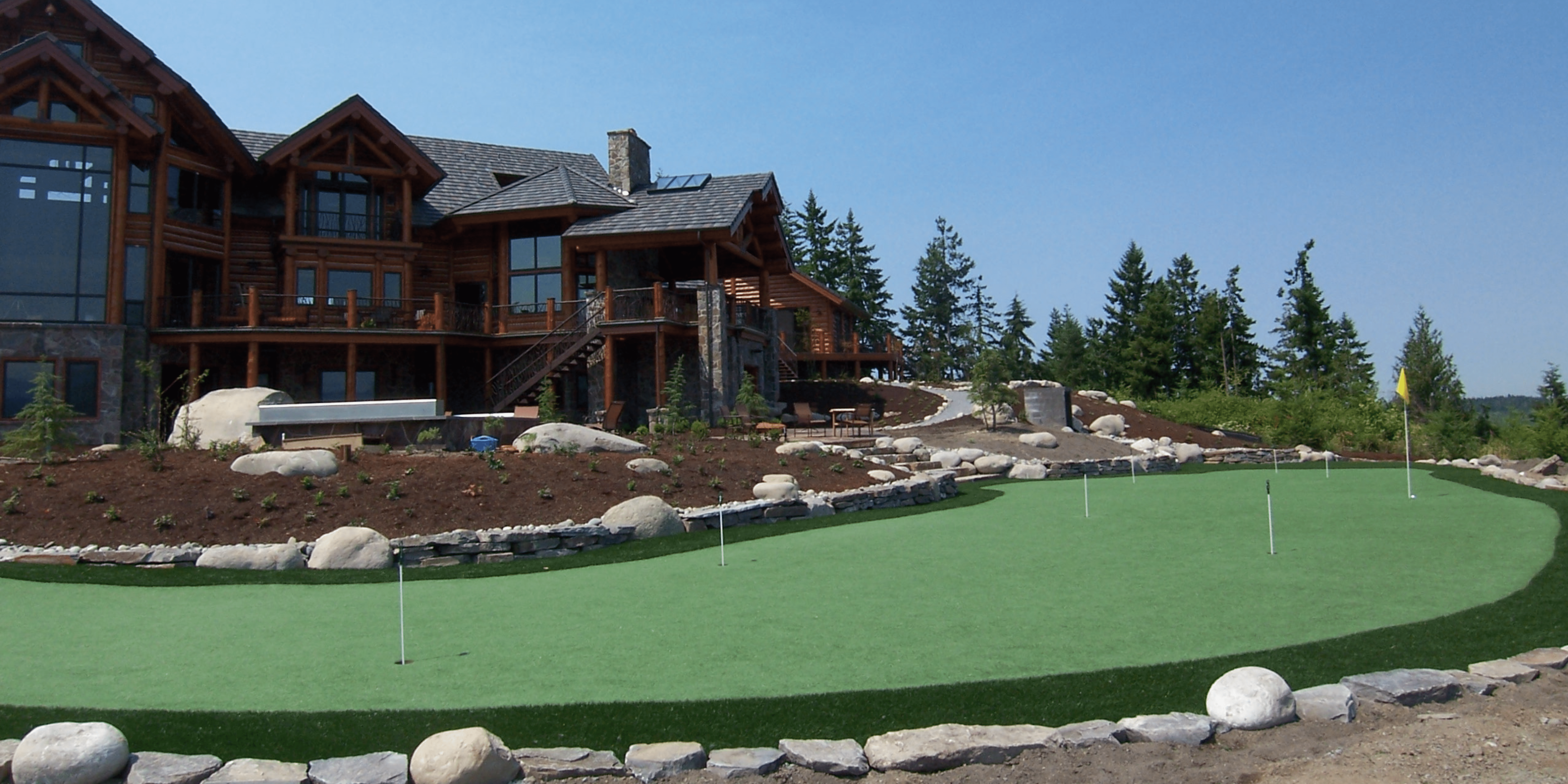 Large house with backyard putting green synthetic turf