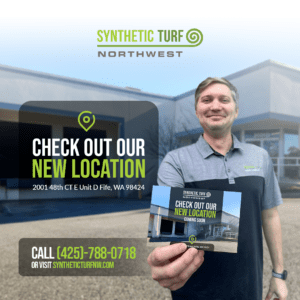 New Location in Fife, Wa. Synthetic Turf Northwest General Manager holding a postcard showing the new location with the new building in the background.